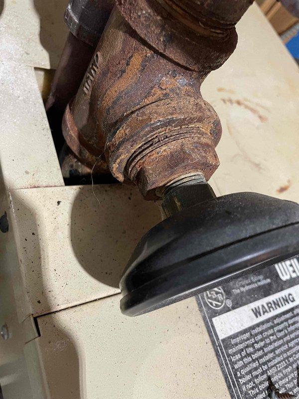 Responded to no heat call for Weil McClain boiler system. Diagnosed locked inducer motor as primary cause of failure. Successfully freed and restored inducer motor operation temporarily, restoring heat to residence. Observed significant corrosion on pipe connections and pressure gauge assembly, indicating system age and deterioration consistent with equipment exceeding 10-year lifespan. Recommended system replacement due to age-related issues and scheduled follow-up consultation.