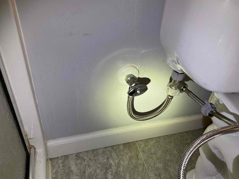 Replaced leaking toilet supply line and angle stop valve in master bathroom. Disconnected hose behind toilet was causing water damage. Installed new stop valve and supply tube to resolve the issue and restore proper water connection.