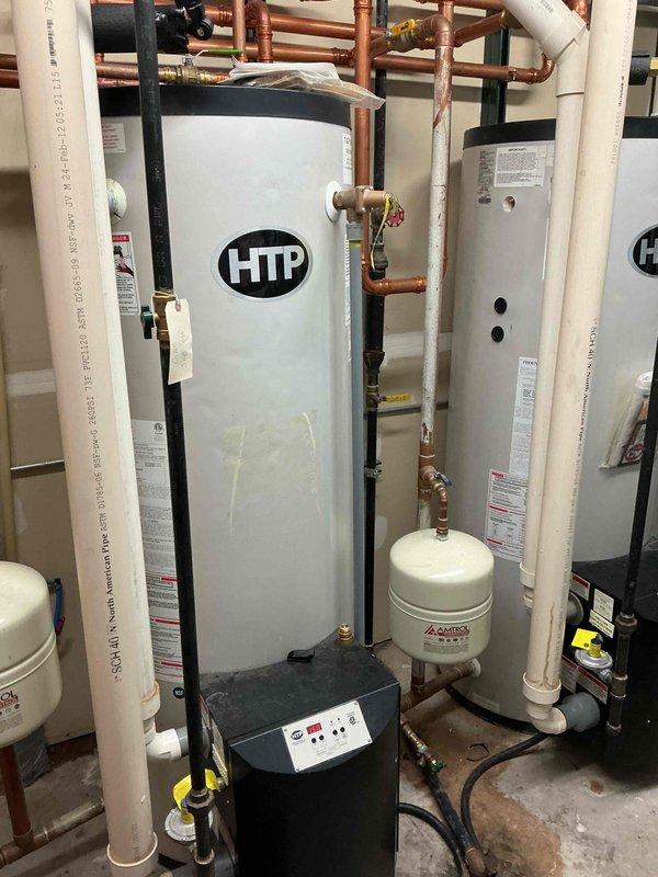 Installed new check valve as requested and replaced damaged elbow fitting. Modified plumbing configuration with unions to allow future isolation of lines and simplified check valve replacement if needed. Work completed on HTP water heater system with associated copper and PVC piping network.