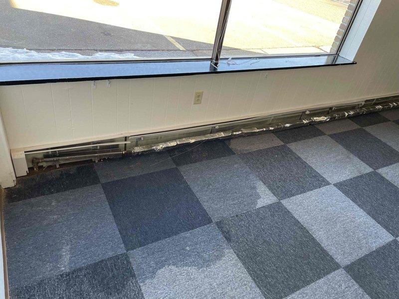Responded to service call regarding baseboard heating unit leaking water onto floor. Upon inspection, found damaged baseboard with copper pipe showing significant corrosion and deterioration. Multiple leak points identified where baseboard was physically removed from wall. Due to building size, lack of isolation valves, and need for specialized fittings, recommended client contact Bartingale for repairs as scope exceeds standard service capabilities.