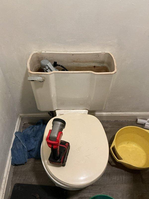 Replaced leaking toilet in Unit 1256 with new Gerber model due to water damage from tank leakage through center back bolt. Discovered recurring issue with white sediment clogging the fill valve, requiring line flushing and installation of new valve after initial replacement became obstructed.