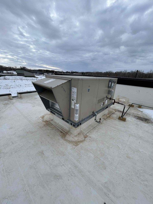 Diagnosed heating issue on commercial 8-12 RTU installed in November by Hovland's. Discovered bath fans/occupancy sensors were improperly wired to economizer through thermostat, causing economizer to open fully during daytime operation and preventing proper heating. Disconnected occupancy wire from RTU control board, allowing economizer to maintain 10% fresh air intake without fully opening. This modification should resolve the continuous heating operation and inability to maintain temperature above 60-65°F.