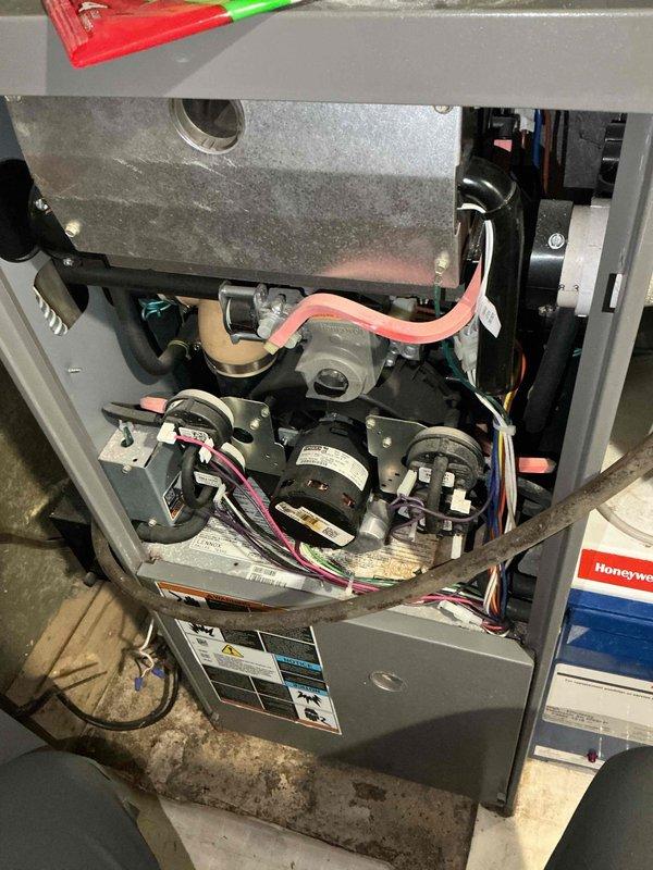 Responded to no-heat call for 18-year-old furnace. Diagnosed flame rollout condition triggering safety switch due to severely compromised heat exchanger with visible rust-through eyelets and gas leakage. Condemned unit as unsafe to operate due to extensive cabinet deterioration and scheduled replacement estimate.