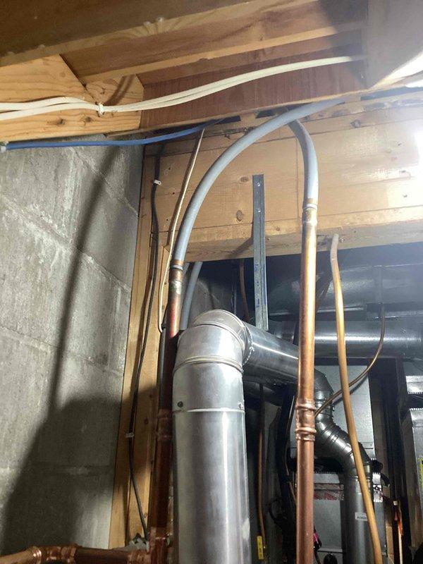 Responded to callback regarding reversed hot/cold water supply and lack of hot water in kitchen. Inspection revealed crossed polybutylene lines in basement ceiling. Corrected issue by cutting the lines and reconfiguring connections above the water heater, restoring proper flow direction throughout the home's plumbing system.