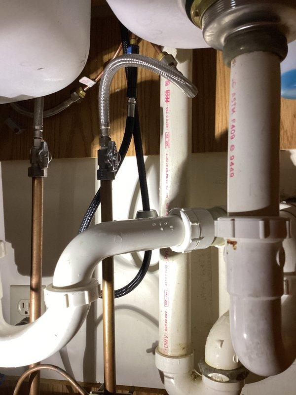 Diagnosed internal leak in kitchen faucet located under sink cabinet. Inspected plumbing system including PVC drain pipes with P-trap configuration, copper supply lines, and braided metal supply hoses. Provided customer with estimate for complete kitchen faucet replacement.