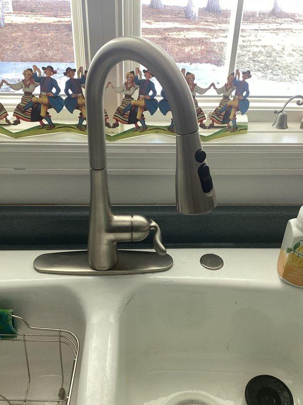 Successfully installed a new Moen kitchen faucet with single-handle control and pull-down sprayer on a circular base plate, replacing customer's previous single-hole model. Additionally, installed customer-supplied toilet seat and addressed shower issues by removing a problematic handheld T-connector that was causing noise and restricted water flow, then reinstalled the showerhead to restore proper function.