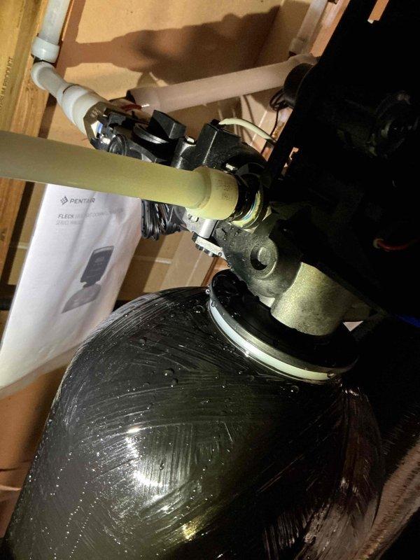 Diagnosed leaking issue at water softener system, identifying a broken female fitting on the softener drain that was not leaking during previous service. Documented the condition with photos showing moisture on the Pentair FLEX filtration tank. Ordered replacement part and scheduled return visit for Monday to complete installation.