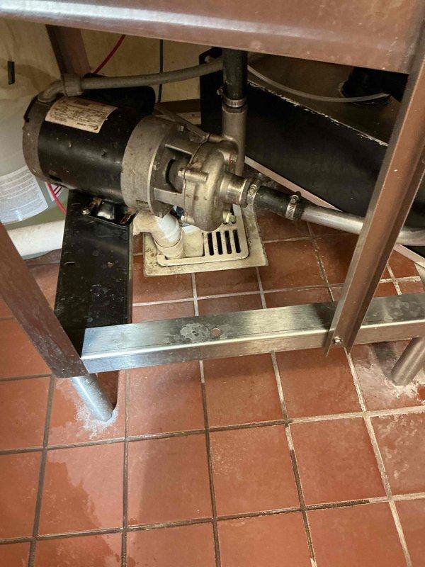 Responded to commercial kitchen water leak issue where dishwasher was backing up during rinse cycle. Upon inspection, determined the 4-inch drain line was causing the backup, which exceeded our equipment capabilities. Documented the motor-pump assembly with photos and referred client to Roto-Rooter for appropriate drain cleaning service. Recommended grease trap pumping as additional maintenance solution.