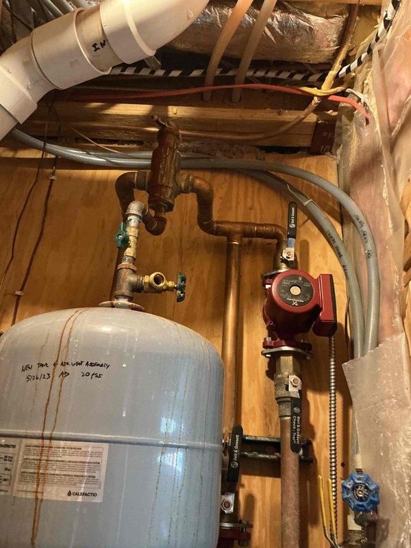 Responded to no-heat emergency call where system displayed error code. Diagnosed issues with hydronic heating system including visible water leak at blue valve connection and rust streaks on pressure tank. Attempted temporary repair to restore heat; system requires comprehensive service including replacement of circulator pump and remediation of copper pipe corrosion at multiple connection points.