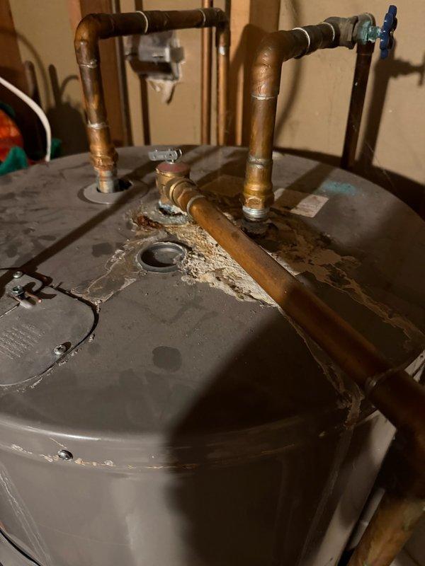 Diagnosed temperature and pressure relief valve leakage on existing water heater with significant corrosion and mineral buildup around pipe connections. Discovered non-functioning main shut-off valve after meter during assessment. Completed installation of new Bradford White water heater and replaced two valves downstream from water meter to restore proper system operation and eliminate leakage.