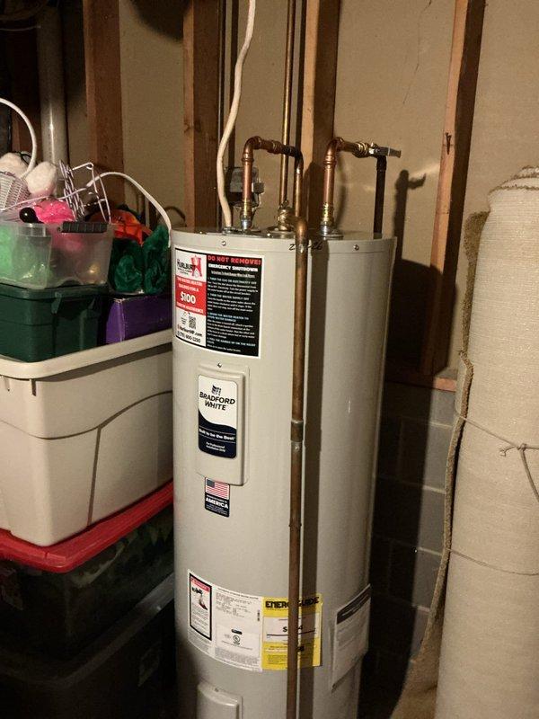 Diagnosed temperature and pressure relief valve leakage on existing water heater with significant corrosion and mineral buildup around pipe connections. Discovered non-functioning main shut-off valve after meter during assessment. Completed installation of new Bradford White water heater and replaced two valves downstream from water meter to restore proper system operation and eliminate leakage.