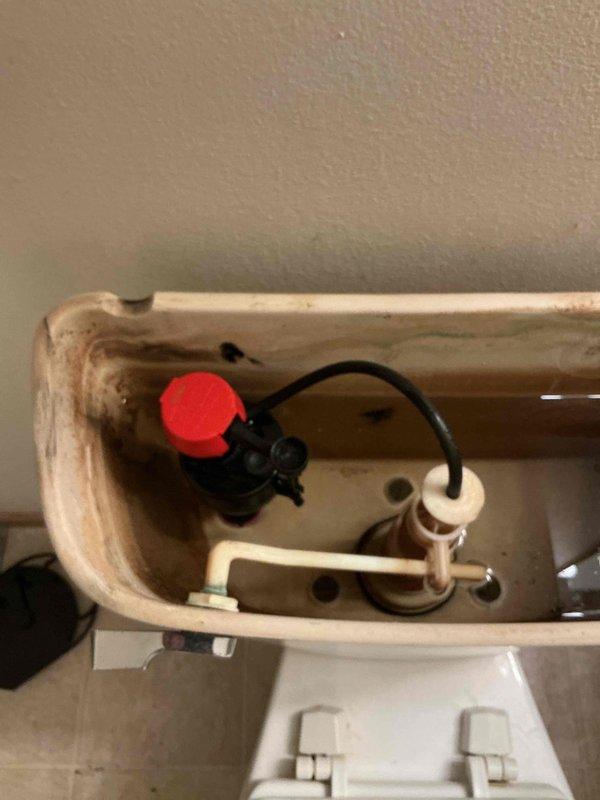 Responded to service call for non-functioning toilet with broken handle and internal components. Diagnosed a snapped flush handle mechanism inside tank and malfunctioning old-style fill valve causing continuous running. Installed new fill valve assembly, restored proper operation, and verified no leaks present upon completion.