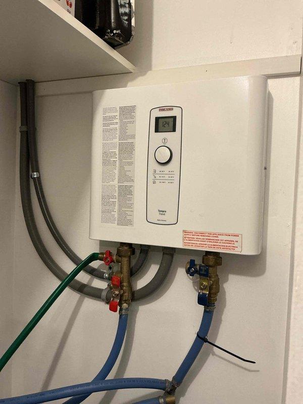 Diagnosed tankless water heater with limited hot water and malfunctioning water softener system. Inspection revealed softener was clogged and skipping regeneration cycles, while the water heater showed significant mineral buildup affecting performance. Provided options for water softener repair/replacement and tankless unit service to restore proper hot water function.