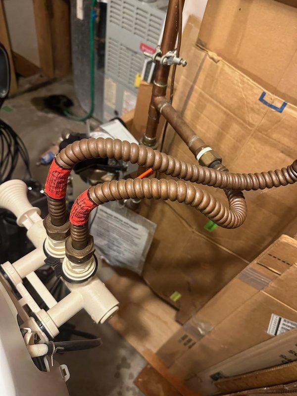Diagnosed and repaired a pinhole leak on the water softener supply connector at the water heater. Replaced deteriorated copper supply lines with new braided flexible connectors, ensuring proper sealing with thread tape at connection points to prevent future leaks.