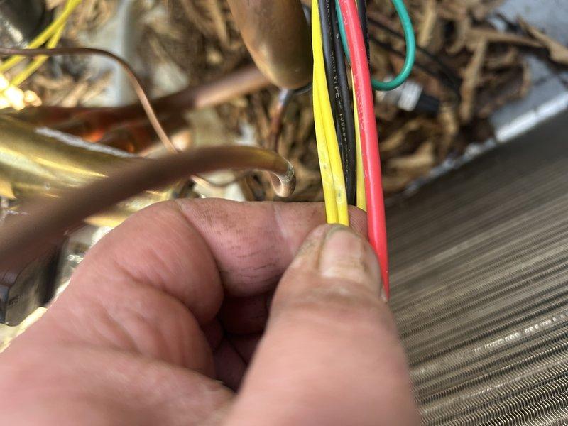 During follow-up service call, identified and repaired shorted low voltage wire in outdoor unit where insulation had worn through from contact with refrigerant line. System was found to be slightly overcharged; removed 1.0 lb of refrigerant, established proper charge levels, and verified proper operation through test run.