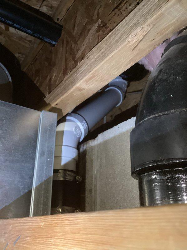 Diagnosed and repaired kitchen drain leak caused by cracked ABS pipe fittings. Accessed damaged section by removing dishwasher and cutting access through wall, then replaced approximately 2 feet of drain piping with new PVC components, securing with appropriate clamps and connectors to prevent future leakage.