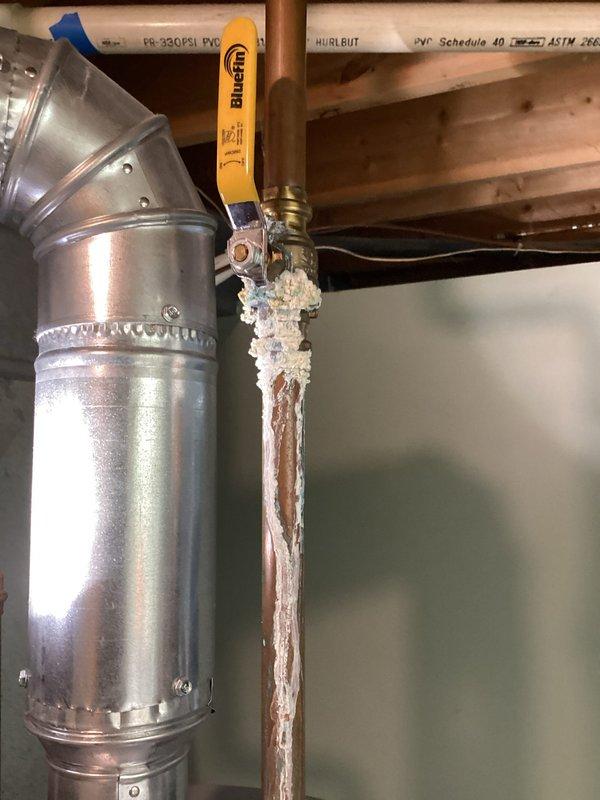 Responded to service call for water heater leaking at the top connection. Diagnosed a pinhole leak in the BluFin ball valve which had caused significant mineral buildup and corrosion on the copper pipe. Replaced the defective ball valve to resolve the leak.