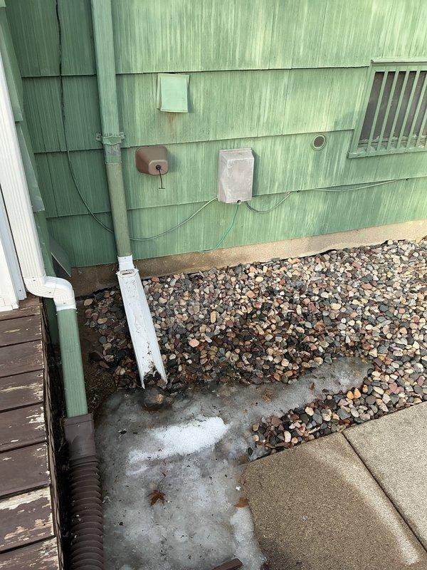 Conducted on-site assessment for laundry room relocation from main level to basement in split-level home. Evaluated existing water heater installation and exterior drainage system to determine feasibility of converting current laundry space into full bathroom while establishing new utility connections in basement for washer/dryer placement.