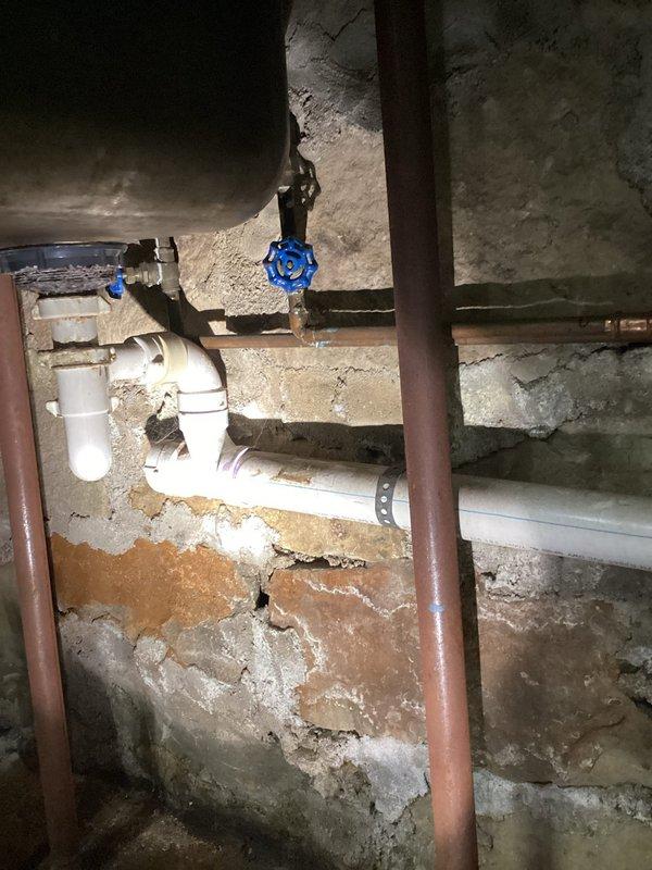 Responded to a service call for a leaking ball valve below a utility sink in the basement. Upon inspection, identified a compromised ball valve in the copper supply line mounted against the concrete wall. Removed the defective valve and installed a new one, successfully resolving the leak issue.