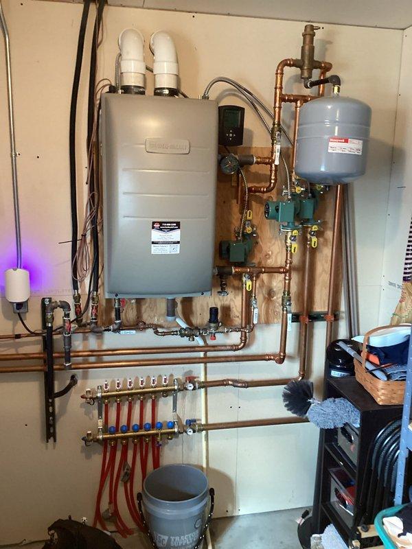 Responded to service call for in-floor heating system with reported leak filling bucket every two days. Upon inspection, identified backflow preventer as source of leak, successfully repaired the issue, and completed documentation for potential replacement if needed in future. System appears to be in good working order with no further leaks observed.