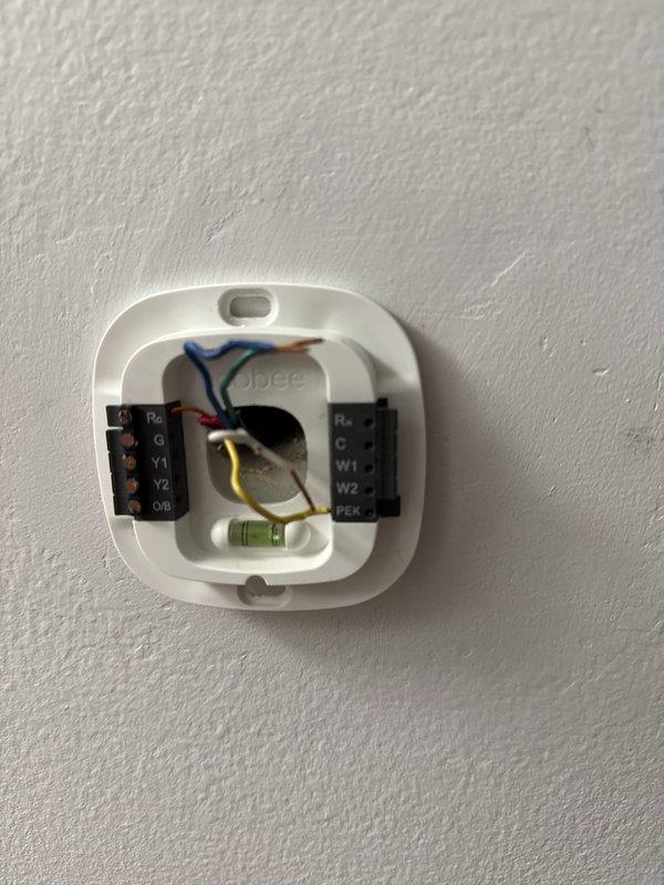 Responded to service call for non-functioning thermostat. Found Ecobee thermostat detached from wall with broken connection prongs. Installed new Honeywell T6 smart thermostat, properly wired all connections, and assisted customer with mobile app setup. System now properly controlling furnace operation.