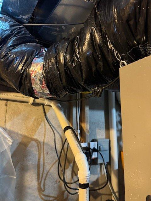 Inspected air exchanger system for reported water leakage from insulated ductwork. Found moisture on fresh air intake and stale air ducts with wet areas below. Enabled defrost function that was previously disabled to prevent freezing in cold conditions. Installed additional straps on insulated flex ducts to create proper slope for drainage back to unit. Advised homeowner that these adjustments would be monitored for effectiveness in resolving the persistent leakage issue.