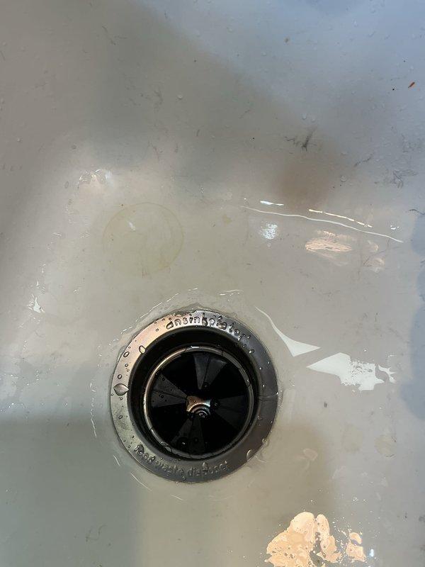 Responded to service call for kitchen sink leak affecting downstairs area. Upon inspection, discovered rotted garbage disposal unit was source of water leakage. Successfully removed damaged unit and installed new Badger Series garbage disposal, properly connecting all PVC drainage piping and ensuring proper seals at drain flange. Final testing confirmed complete resolution of leak issue with no further water intrusion.