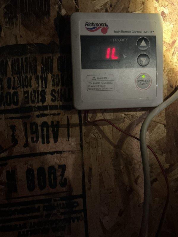 Diagnosed Richmond tankless water heater (approx. 20 years old) displaying error code L1 on the UMC-117 remote control. Determined unit requires descaling service as system has never had maintenance performed despite being on city water with no filtration. Recommended installation of service tees to facilitate proper maintenance going forward.