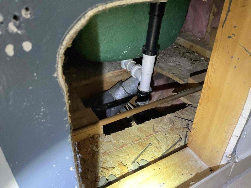 Conducted an estimate for master bathroom remodel, specifically assessing requirements for installation of a free-standing tub with floor-mounted tub filler. Inspection revealed existing plumbing configuration through wall cavity, including PVC drain piping and associated connections that would require modification to accommodate new fixtures.