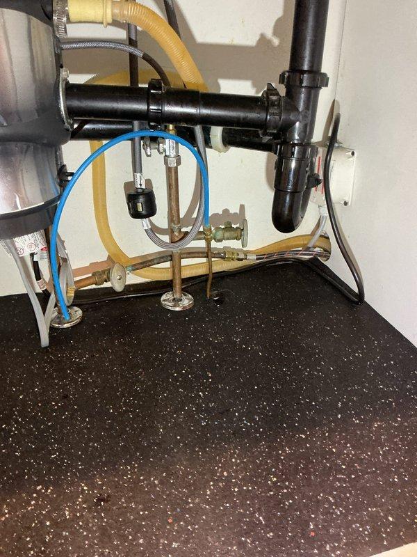 Replaced leaking plastic connector on refrigerator water supply line under kitchen sink with copper piping and new shut-off valves. Verified proper operation with no leaks after installation.