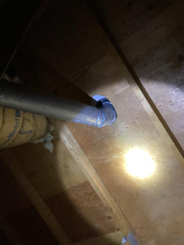 Inspected water heater venting system in attic and identified flue pipe detachment at 45-degree connection point at roof penetration. Documented condition with photos showing exposed metal ductwork with compromised blue connection collar. Scheduled follow-up service with heating technicians to properly reconnect and secure the flue system.