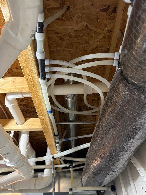 Completed FRP plumbing inspection of residential property, examining newly installed PVC piping system with proper connections and securing mechanisms within wood-framed structure, and verified functionality of bathroom sink fixture with chrome faucet. Documentation and inspection sheet completed with supporting photographic evidence of all plumbing components.
