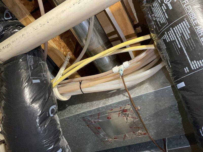 Conducted comprehensive plumbing inspection of residential property, examining under-sink supply lines with shut-off valves and attic PVC drainage system. All connections were verified secure with no signs of leaks or deterioration; supply lines and fixtures were confirmed in good working condition with proper installation.