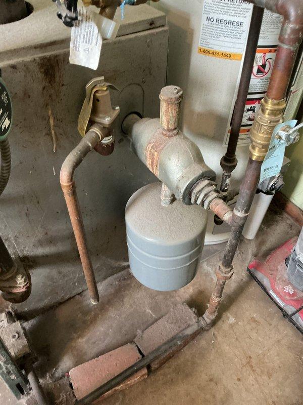 Responded to service call for 40+ year old boiler with no heat to basement zone baseboards. Diagnosed air-locked bottom floor zone and observed evidence of water leakage from the heat exchanger on the bottom block. Performed system maintenance by draining, filling, and purging baseboard zones in basement, successfully restoring heat to the affected areas, though noted the boiler has no repair option for the heat exchanger leak.