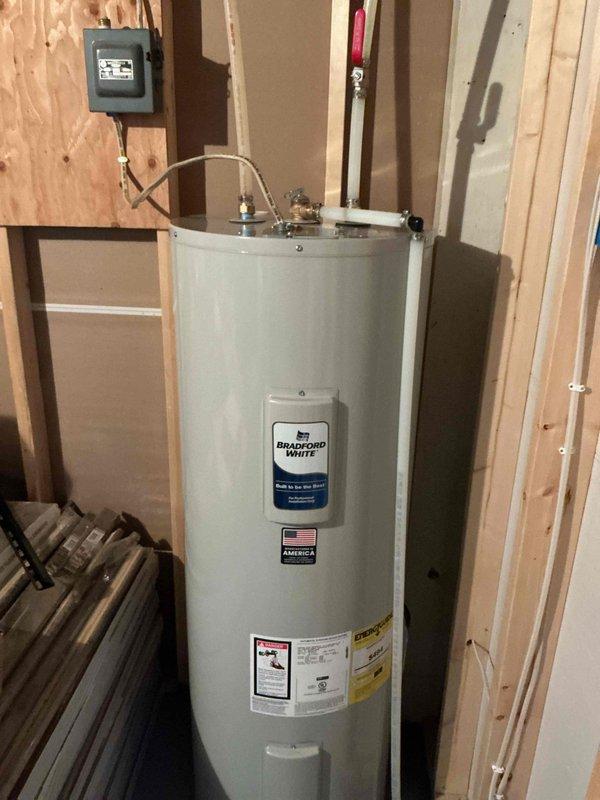 Replaced 26-year-old Bradford White electric water heater experiencing electrical issues with new 50-gallon electric model. Installation completed in utility area with proper electrical connections and copper piping, restoring hot water service to the residence.