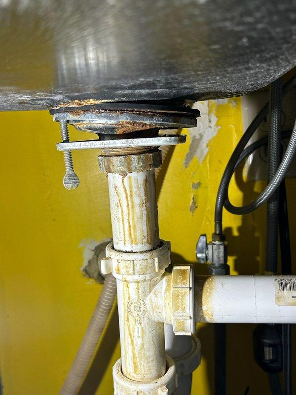 Responded to a service call for a kitchen sink leak. Upon inspection, discovered a rusted basket strainer causing water seepage underneath the sink. Successfully replaced the damaged strainer with a new unit, resolving the leak issue. Visual inspection confirmed proper installation with no further leakage.