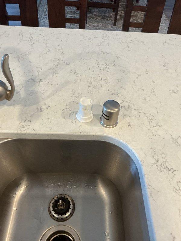 Responded to a service call regarding a reported issue with the airgap device at the customer's kitchen countertop. Upon thorough inspection of the kitchen sink area (which features a stainless steel undermount sink in white marble/quartz countertop), no problems were detected with the airgap device. Documented the kitchen sink configuration and HVAC system with photographs for service records. No repairs were necessary.