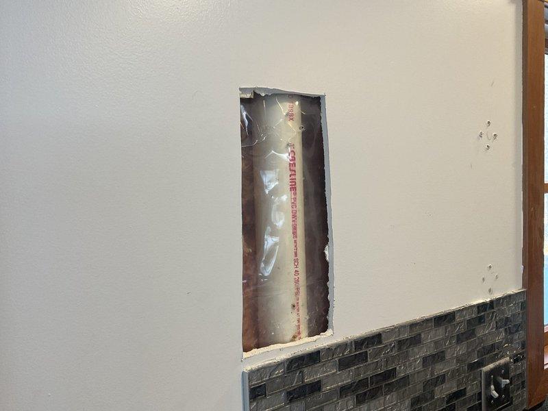 Responded to emergency call for pipe damage in kitchen. Customer had inadvertently drilled through a 3" PVC stack while installing shelves. Successfully repaired the damaged section by cutting out the affected portion and installing new PVC pipe with appropriate fittings, restoring proper drainage function.