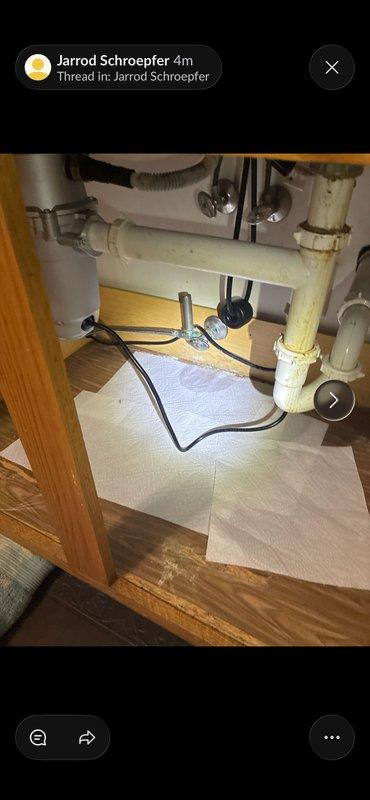 Identified and repaired a leaking ABS T-fitting behind the wall that was causing water to penetrate from the kitchen sink to the lower level above the washing machine. Replaced damaged T-fitting and associated piping to resolve the leak, with visual inspection confirming proper drainage function through the newly installed PVC plumbing components.