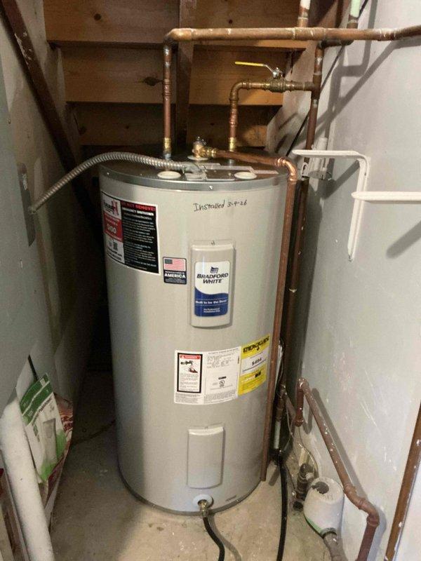 Successfully replaced a 50-gallon short electric Bradford White water heater in utility area. Installation included proper connection of copper supply lines and flexible connections. Documented installation with before and after photographs for service record.
