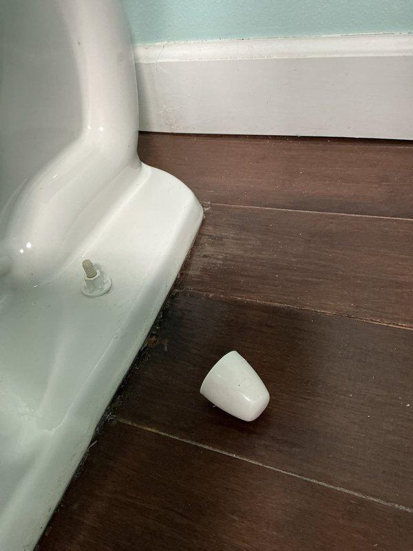 Returned to address previous toilet installation issue where caulking was improperly applied and bolt caps were missing. Cleaned up excess silicone and plaster residue around toilet base, then properly installed missing bolt caps to complete the fixture installation professionally.