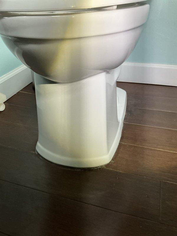 Returned to address previous toilet installation issue where caulking was improperly applied and bolt caps were missing. Cleaned up excess silicone and plaster residue around toilet base, then properly installed missing bolt caps to complete the fixture installation professionally.