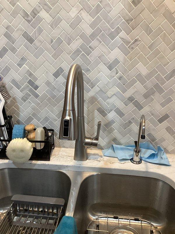 Completed installation of customer-supplied kitchen faucet with pull-down sprayer feature and replaced the existing RO (reverse osmosis) filter cartridges. System was suspected to have minor clogging issues prior to service; all components were properly installed and tested with no leaks observed upon completion.
