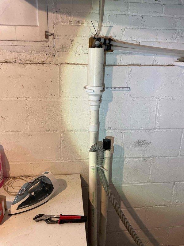 Responded to service call for intermittent water discharge from drainage pipe in basement. Diagnosed issue with improperly secured drain lines where they connect to standpipes. Extended pipes slightly and installed J-hook to secure lines to wall, preventing future water discharge incidents.