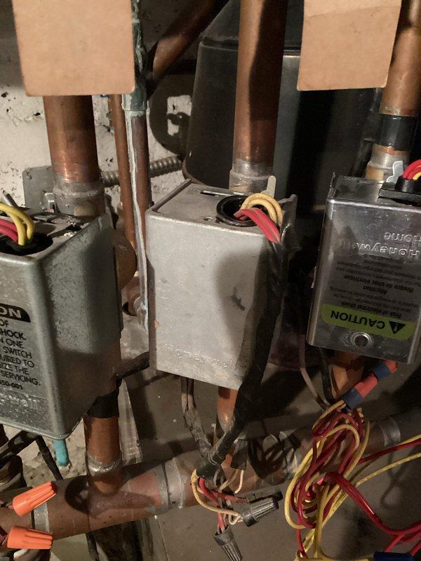 Diagnosed multiple issues with the boiler system including a bypassing zone valve causing overheating in one room, non-functioning pressure gauge, immobile fill valves, leaking pressure relief valve, and potentially waterlogged expansion tank. Documented system components including control modules mounted on copper pipes and the RenewAire unit with associated ductwork for comprehensive repair estimation.