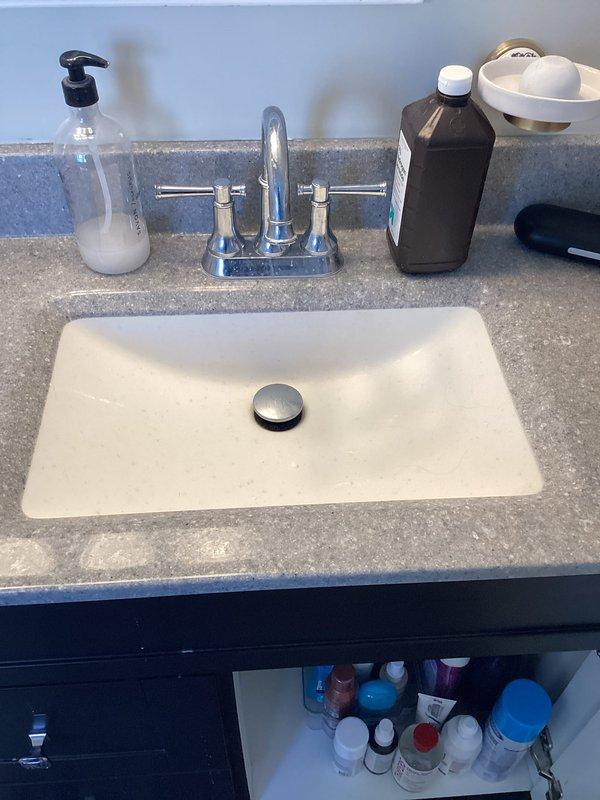 Performed comprehensive plumbing inspection of bathroom fixtures. Examined bathroom sink, faucet, and drain for proper functionality with no visible leaks detected. Inspected toilet tank internal components, noting significant mineral buildup and aging on Kohler float valve mechanism, flapper valve, and tank walls. Recommended descaling treatment and potential replacement of internal components to prevent future issues.