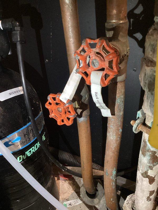Responded to service call for two plumbing issues: outdoor spigot with dripping shut-off valve and upstairs shower experiencing temperature fluctuations. Diagnosed Kohler cartridge failure in shower; tightened packing nut as temporary measure and assisted customer with ordering replacement cartridge. Inspected water heater system and documented existing valve configuration with photographs.