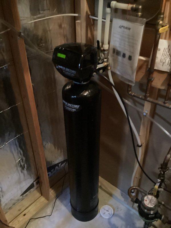 Performed complimentary new customer plumbing inspection, focusing on a 13-year-old water heater that customer reported has never been flushed. Inspected existing water treatment system (Doctor's brand water softener with digital control head) and examined plumbing connections including valve assembly with copper piping. Discussed customer's concerns about elevated water bills potentially related to outdoor spigot issues and provided recommendations for water heater maintenance.