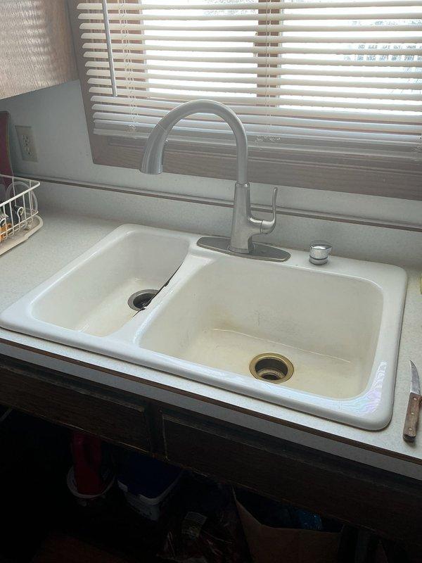 Completed estimate for installation of customer-supplied sink, drain, MOEN faucet, and garbage disposal in kitchen. Assessed existing double-basin kitchen sink setup with current brushed nickel/stainless steel faucet for replacement. Customer informed of COD payment terms if they decide to proceed with the proposed work.