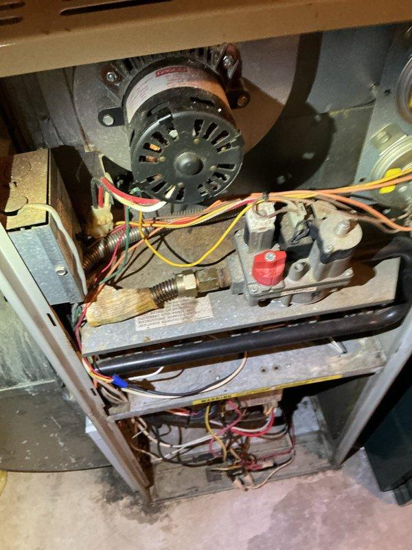 Performed scheduled maintenance tune-up on two furnace systems (93 and 94 year models). Identified critical issues in upstairs unit including cracked heat exchanger, gas valve malfunction, and oil leakage from blower motor. Basement unit inspection revealed blower motor oil leakage and thermostat placement concerns. Documented system conditions with detailed component photography for replacement recommendations.